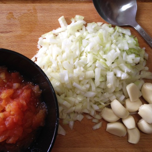 The onions and tomatoes already prepped.  Both should be chopped as fine as possible.   The garlic is saved, to be pressed fresh on top of the sauté.